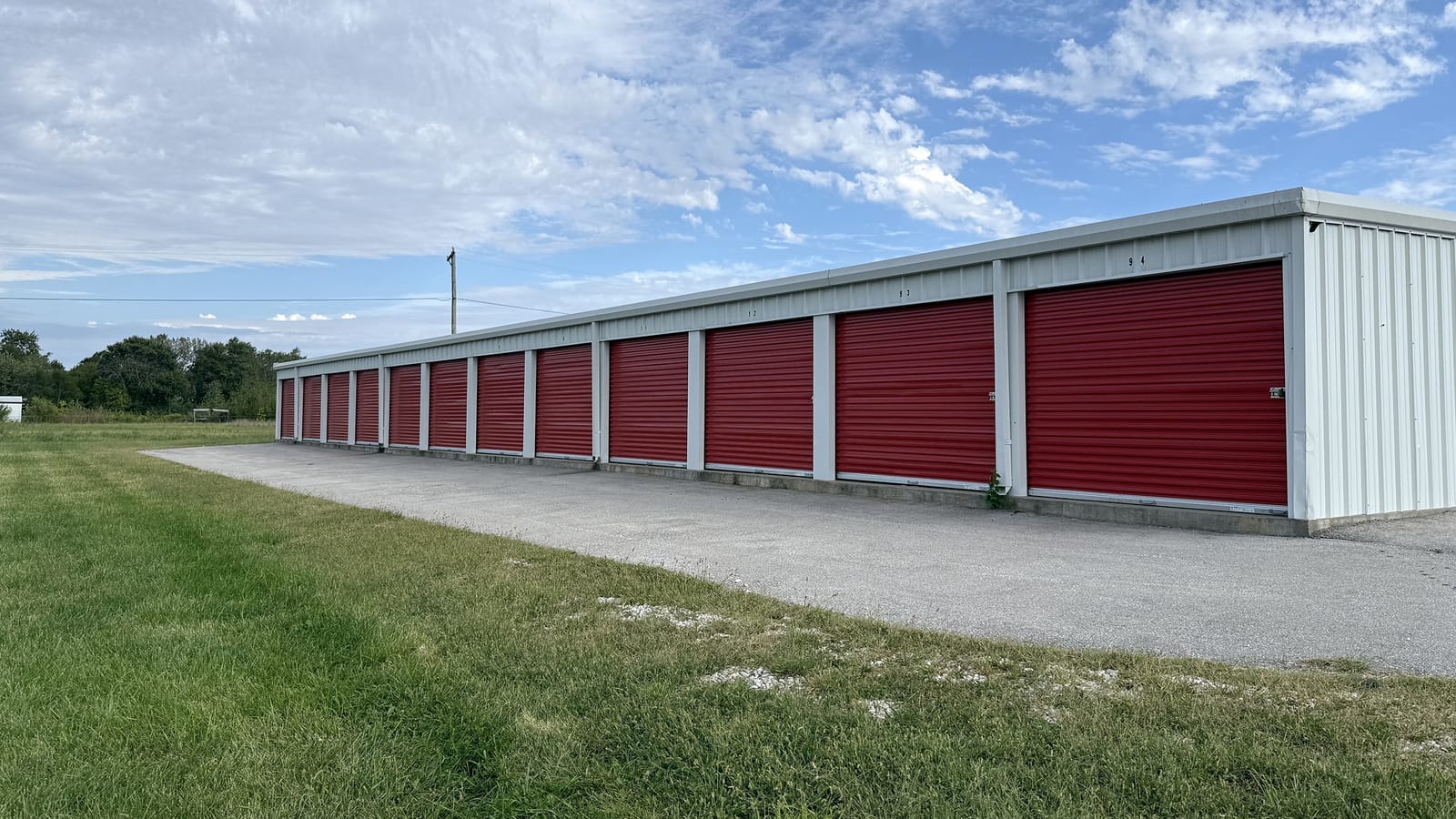 Red storage doors and the drive-up lane at Just Store It in Moberly
